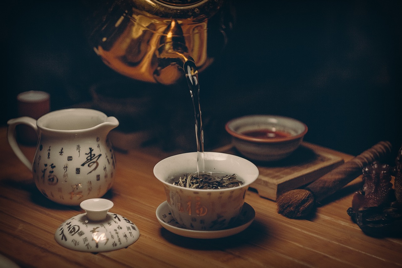 Pouring tea into mugs from a teapot