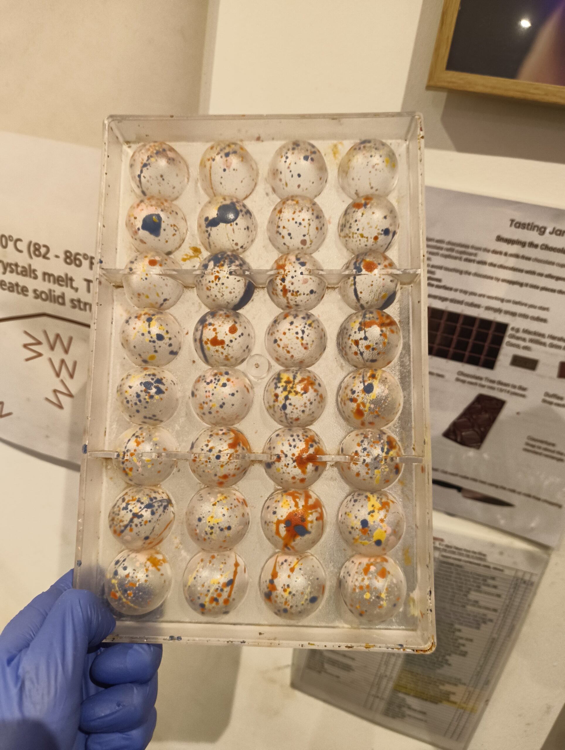 Plastic truffle moulds painted with dark coloured cocoa butter