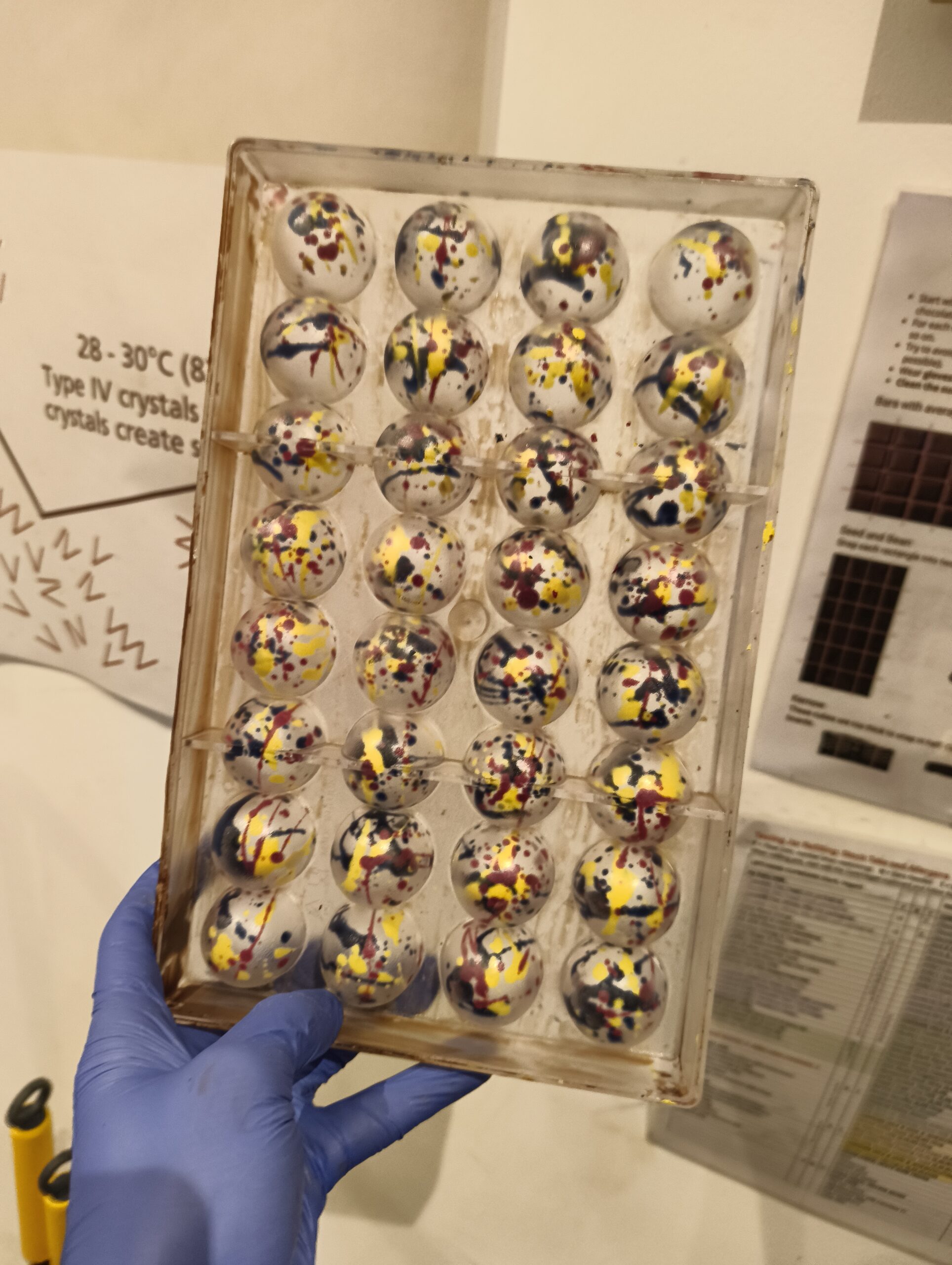Plastic truffle moulds painted with coloured cocoa butter