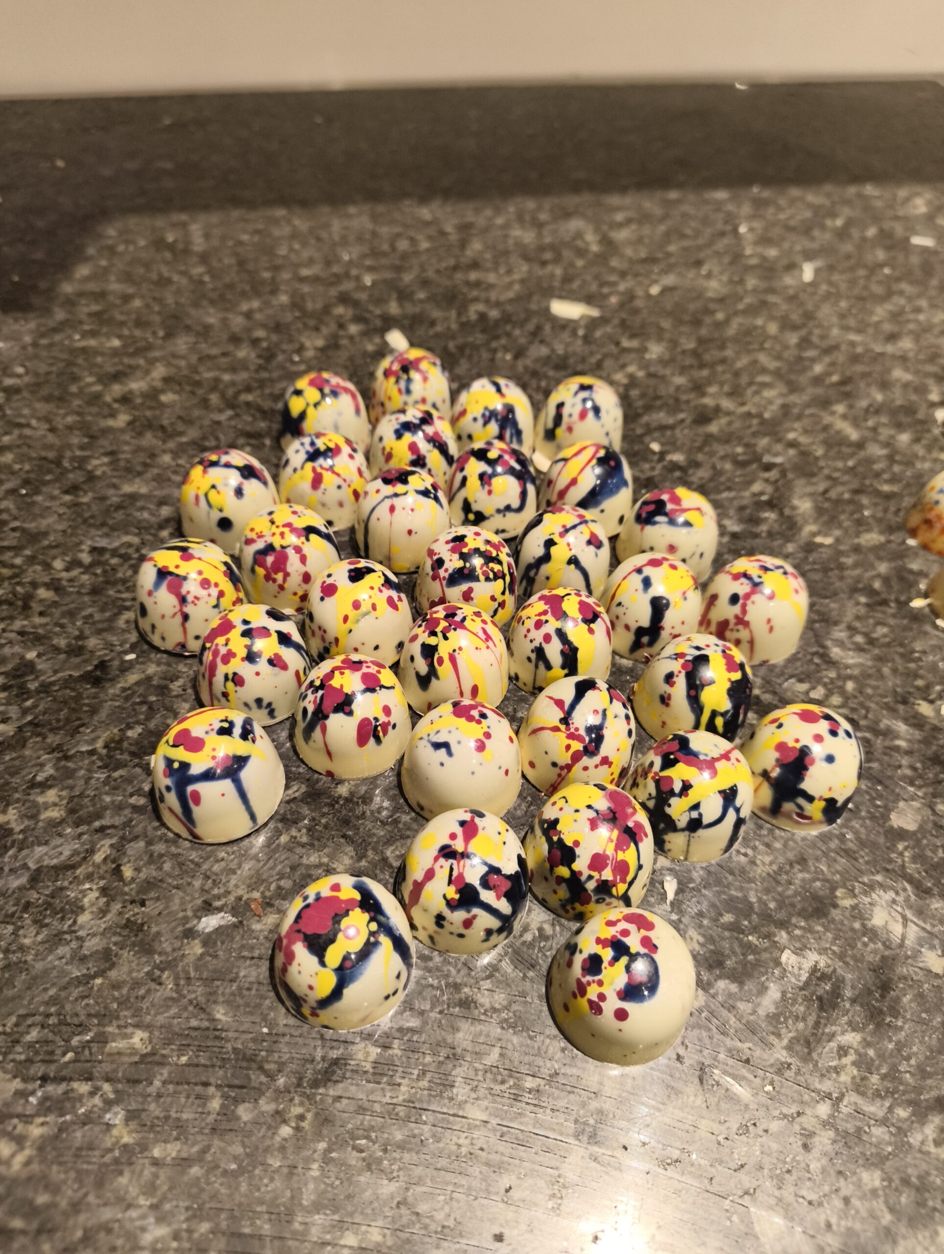 A collection of multicoloured white chocolate birthday cake truffles